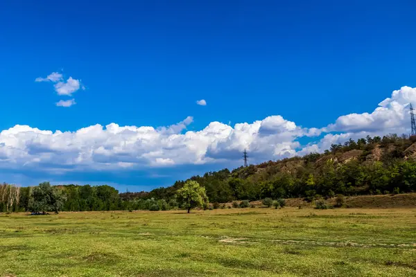 Bulutları ve mavi gökyüzü olan güzel bir manzara.