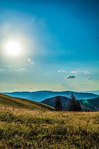 Dağları ve mavi gökyüzü olan güzel bir manzara.