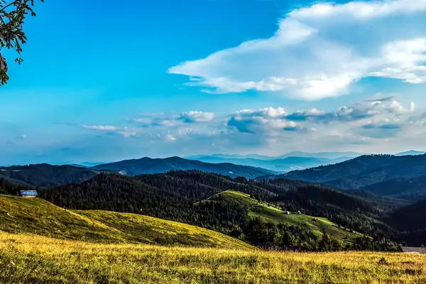 Dağları ve mavi gökyüzü olan güzel bir manzara.