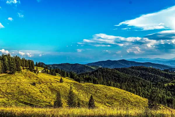 Dağları ve mavi gökyüzü olan güzel bir manzara.