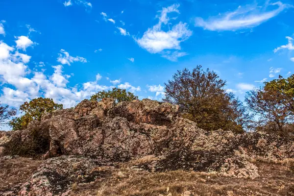 Sonbahar mevsiminde mavi arka planda kayalar ve çimenler olan manzara