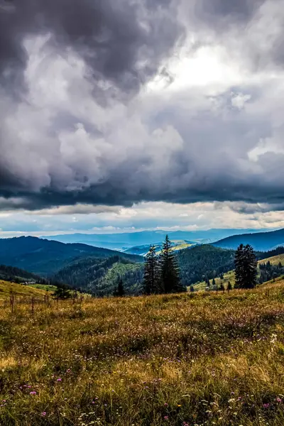 Kırsaldaki tepelerin üzerinde bulutlu bir gökyüzü olan güzel bir manzara.