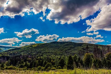 Dağları ve mavi gökyüzü olan güzel bir manzara.