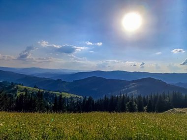 Dağları ve mavi gökyüzü olan güzel bir manzara.