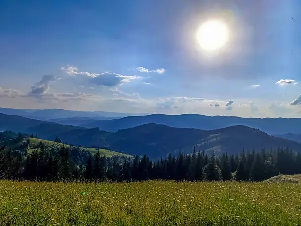 Dağları ve mavi gökyüzü olan güzel bir manzara.
