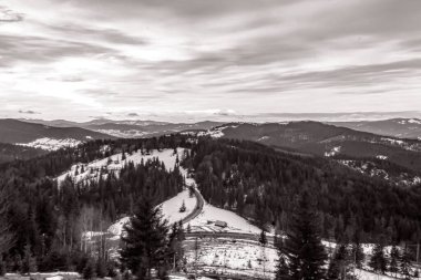 Karpatlar 'ın güzel kış manzarası. Önünde karla kaplı tepeler ve mavi gökyüzünün arka planında güneş.