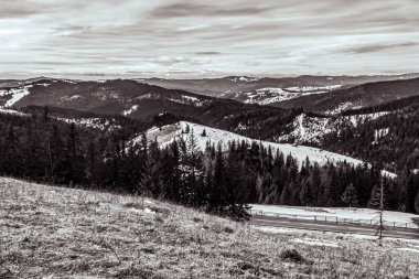 Dağların karla kaplı olduğu siyah beyaz bir fotoğraf..