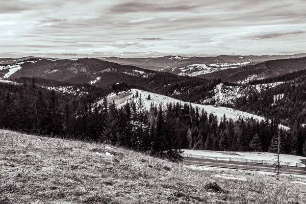 Dağların karla kaplı olduğu siyah beyaz bir fotoğraf..