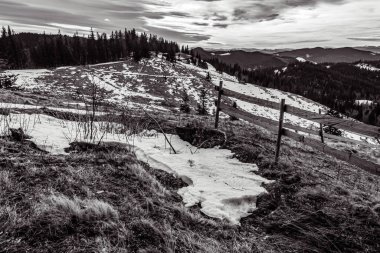 Kışın kayalık bir dağ manzarası, bulutlu bir gün, siyah ve beyaz