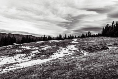 Bulutlu bir günde karla kaplı kayalık tepelerin güzel bir görüntüsü.