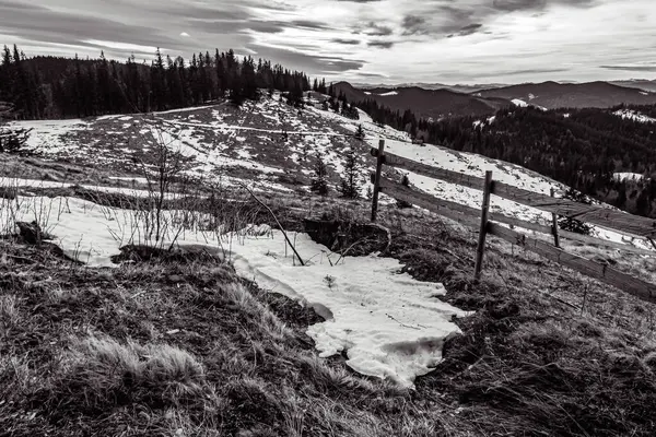 Kışın kayalık bir dağ manzarası, bulutlu bir gün, siyah ve beyaz