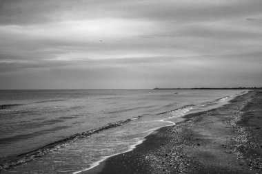 Deniz ve bulutlu mavi gökyüzü olan güzel bir sahil.