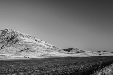 Arkasında dağ olan bir çöl resmi.