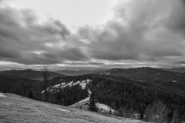 Dağlardaki kış manzarasının siyah beyaz fotoğrafı.