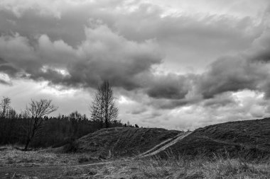 Dağlardaki bir dağ yolunda siyah beyaz bulutlar.