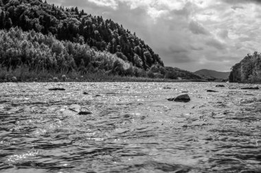 Dağ nehrinin kıyısındaki kayaların ve nehrin siyah beyaz görüntüsü