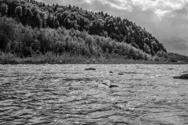 Arka planda nehir ve dağ gölü olan güzel bir manzara.