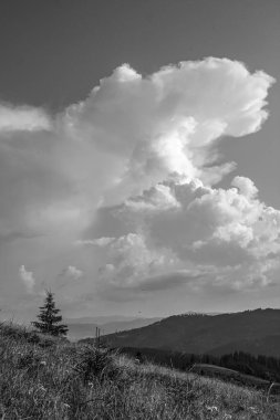 Dağların arka planında siyah beyaz bulutlar.