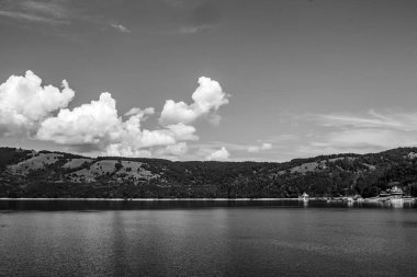 Gölün üzerinde siyah beyaz bulutlar