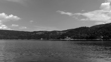 Gölde siyah beyaz ve beyaz bulutlar