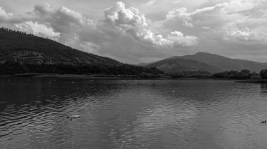 Dağların üzerinde siyah beyaz bulutlar