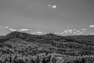 Siyah beyaz bulutlu kayalık bir dağ manzarasının güzel bir görüntüsü.