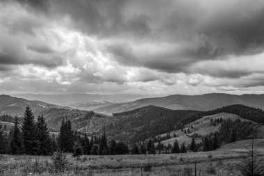 Bulutlu gökyüzü ile siyah ve beyaz dağlar