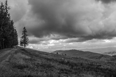 Siyah ve beyaz bulutları olan güzel bir dağ manzarası.