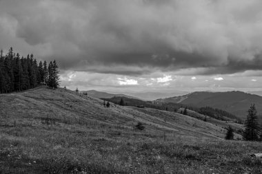 Arkaplanda kara bulutlar ve dağlar