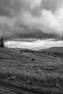 Yazın dağların üzerinde siyah beyaz bulutlar