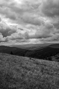 Dağların üzerinde siyah beyaz bulutlar ve gökyüzü