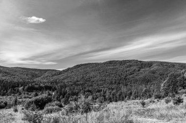 Dağları ve bulutlu gökyüzü olan güzel bir manzara.