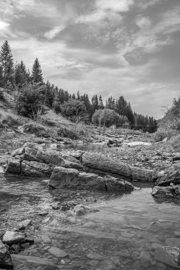 Dağlarda suyla çevrili kayaların dikey görüntüsü.