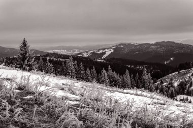 Kışın çekilmiş siyah beyaz bir dağ fotoğrafı.