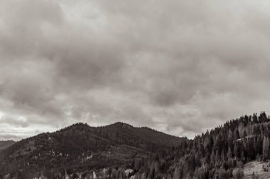 Dağların üzerinde siyah beyaz bulutlar