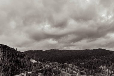 Dağların üzerinde siyah beyaz bulutlar