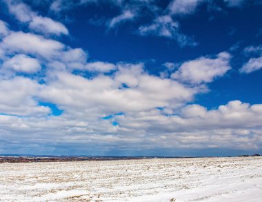 karla kaplı tarla ve mavi gökyüzü