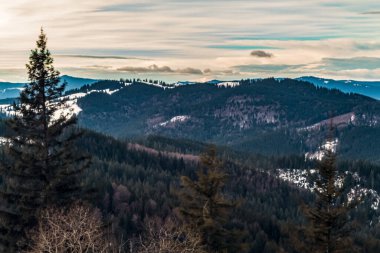 Kış manzarası, karla kaplı ağaçlar, güzel gökyüzü ve dağlar.