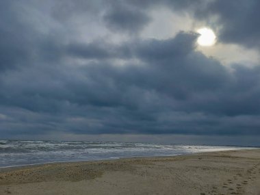 Arka planda bulutlu bir gökyüzü olan bir denizin dikey çekimi