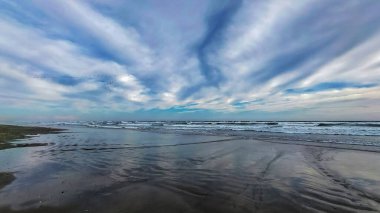 Bulutları ve denizi olan güzel sahil