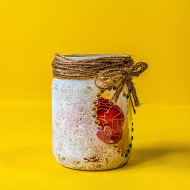 Sarı arka planda kırmızı kurdeleli sarı kavanoz