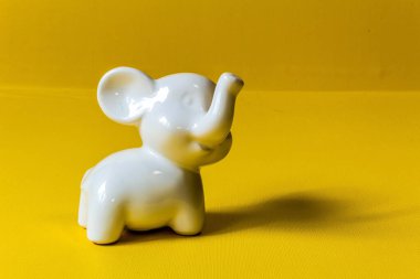 Beyaz oyuncak fil sarı arkaplanda izole edilmiş..