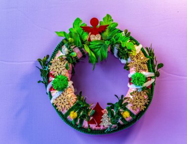 Yapay çiçeklerden yapılmış güzel bir Noel çelengi..