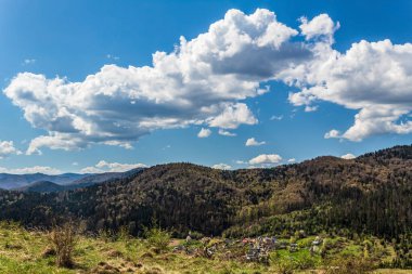 Dağları ve mavi gökyüzü olan güzel bir manzara.