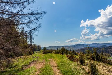 Dağları ve mavi gökyüzü olan güzel bir manzara.