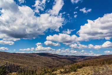 Dağları ve mavi gökyüzü olan güzel bir manzara.