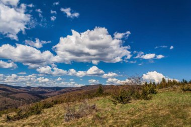 Dağları ve bulutlu gökyüzü olan güzel bir manzara.