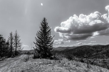 Dağların üzerinde siyah beyaz bulutlar.