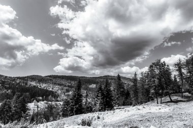 Dağların üzerinde siyah beyaz bulutlar