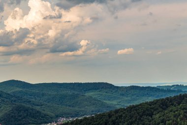 Güzel yaz manzarası. Arka planda dağlar, tepeler, orman ve bulutlar..